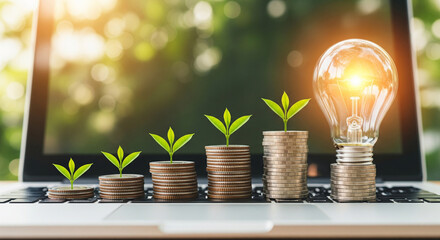 Financial growth concept with stacked coins and a glowing light bulb on a laptop
