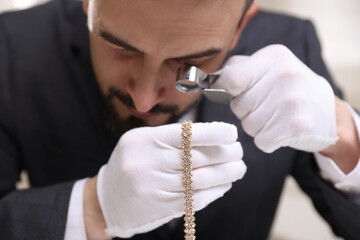 Appraiser evaluating luxury necklace indoors, closeup view