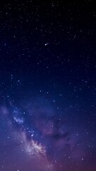 Obraz premium A shooting star streaks across a vast deep blue night sky filled with countless stars