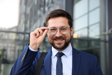 Portrait of successful businessman near office building