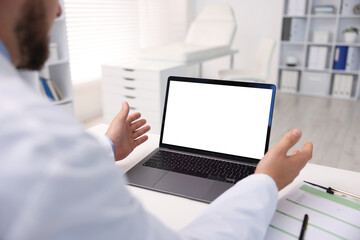 Doctor having online consultation via laptop in clinic, closeup