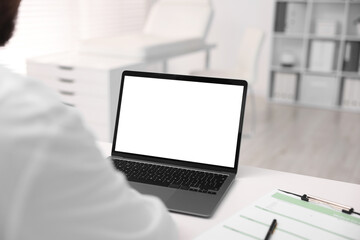 Doctor having online consultation via laptop in clinic, closeup