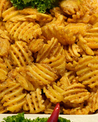 Crispy waffle fries served on a platter with fresh greens