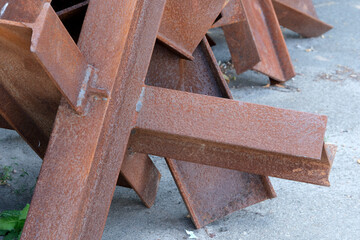 Rusty steel beams resting on a concrete surface in a construction area