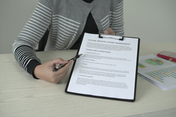 A real estate agent is explaining the terms and conditions of the lease agreement to tenant and...