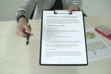 A real estate agent is explaining the terms and conditions of the lease agreement to tenant and...