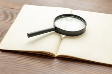 old book and magnifying glass close up