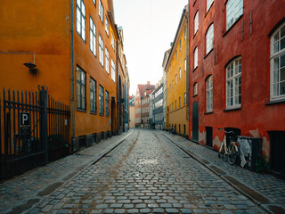 Magstræde in Copenhagen, Denmark, glows at dawn with colorful historic buildings and cobblestone charm—one of the city’s oldest streets in a peaceful, picturesque setting.