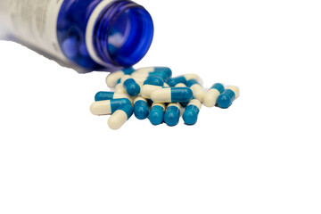 a blue bottle with white and blue pills on a white background