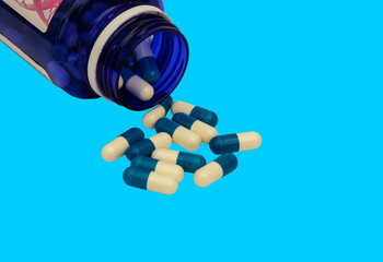 a blue bottle with white and blue pills on a blue background