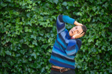 Man feeling astonished with hands on head and ivy background