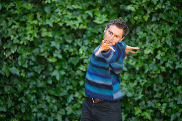 Dancer performing against green ivy wall background