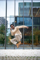 Enthusiastic businessman jumping with joy in front of office building