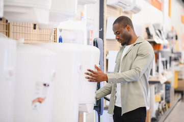 Customer choosing water heater in electronics store appliance section
