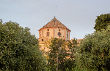 Naklejka premium Gothic-style Sant Martí Parish and clock tower in Altafulla, Catalonia, rising over the charming historic town. A Spanish architectural gem.