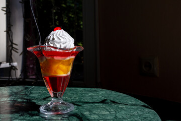 Colorful dessert served in a vintage glass dish on a marble table