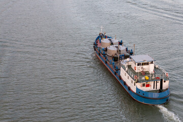 Cargo ship navigates river transporting goods during sunset
