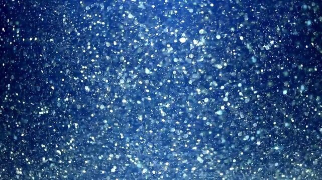 Falling snowflakes and shiny ice crystals drift across a blue winter sky, evoking holiday warmth and seasonal charm