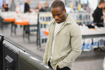 Customer choosing tv in electronics store at mall