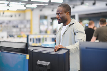 Customer choosing tv in electronics store at mall