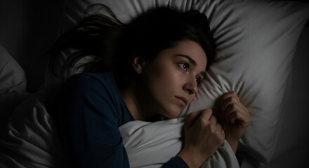 Sleepless night: Young woman lying awake in bed feeling anxiety and sadness