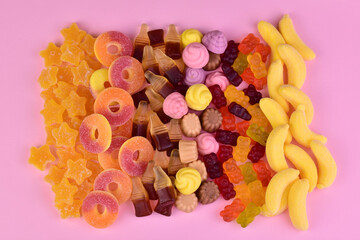 Multicolored assortment of sweets confectionery, jelly candies on a pink background. Flat lay.
