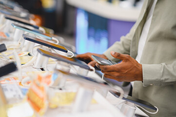 Customer comparing smartphones in electronics store