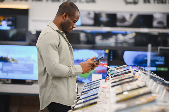 Customer comparing smartphones in electronics store