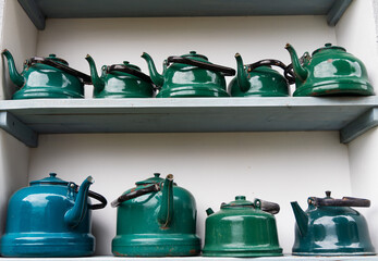 old metal green teapots on a shelf 