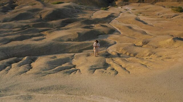 A drone shot from above shows Jesus walking through Judea�s desert in the daylight, wearing a white robe and holding�a�staff.