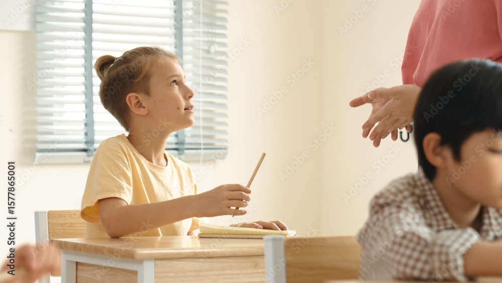 Aufkleber beautiful teacher explaining test while caucasian boy doing classwork and listening explanation. cut