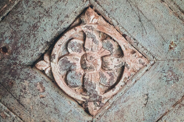 Antique floral stone carving showcases intricate detail and aged textures, adding vintage charm to any design.