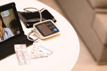 Blood pressure measuring device with pills on the table.