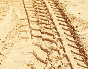 A stylized abstract rendering of a modern tank track imprinted on a dusty, vast landscape, showing military presence.