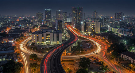 Night cityscape with light trails on elevated roads and illuminated buildings in urban environment