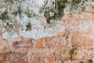 Distressed brickwork texture showing aged wall surface, weathered stone and peeling plaster creating vintage backdrop.