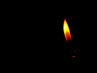Burning gas lighter on dark background