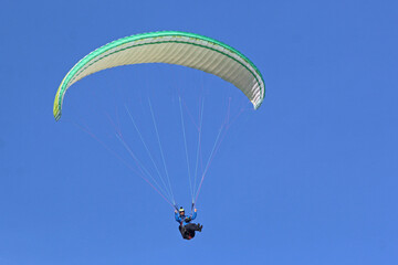 Paraglider flying in a blue sky	