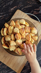 Child Reaching for Homemade Sugar-Coated Cookies in Bowl