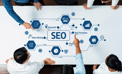 Business professionals engage in a collaborative session analyzing SEO strategies with visual...
