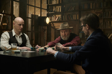 Male company enjoying a table game in a smoky library