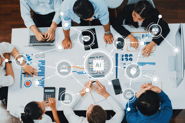 A dynamic business meeting showcasing professionals collaborating over data analysis with laptops and charts, emphasizing teamwork and technology in a modern office. Amity