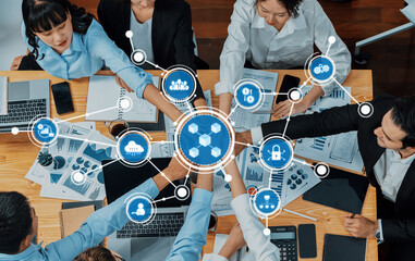 A vibrant office scene showcasing a diverse team working collaboratively over a table filled with documents and digital devices, symbolizing innovation and teamwork. Amity