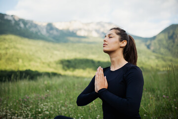 Woman practicing yoga exercise outdoor in nature