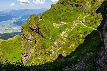 Summer mountain hiking in Tyrol (Austria) - path along the rock in the ascent to the Kitzbüheler Horn, secured with a steel rope