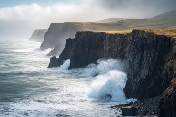 Rugged cliffs rise sharply from the churning sea as powerful waves crash against the rocks. The sky is filled with mist, creating a captivating atmosphere along the coastline