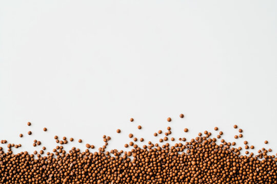 A border of fish food pellets isolated on white background with copy space