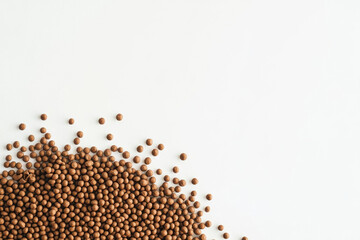 A corner of fish food pellets isolated on white background with copy space
