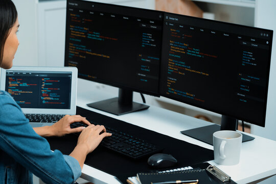 Young Asian in IT developer creating with typing online information on pc with coding program data of website application, wearing jeans shirt. surrounded by safety analysis two screens. Stratagem.
