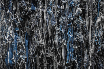 Detailed view highlighting the complex texture of torn denim repurposed as recycled jeans,...